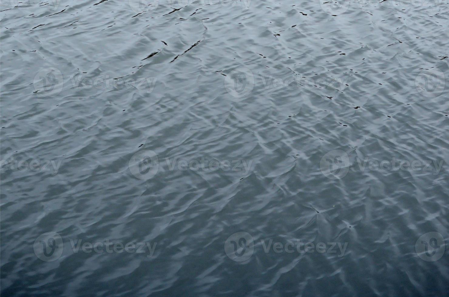 The texture of the water in the river under the influence of wind. A lot of shallow waves on the water surface photo