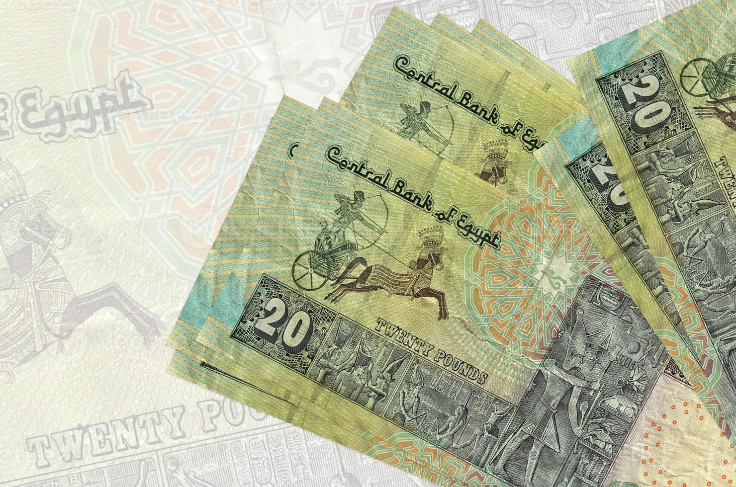 20 Egyptian pounds bills lies in stack on background of big semi-transparent banknote. Abstract presentation of national currency photo