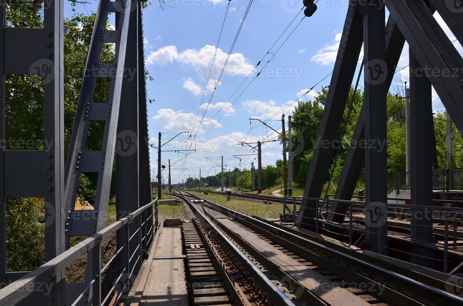 Summer day railway landscape with a view from the railway bridge to the suburban passenger station photo