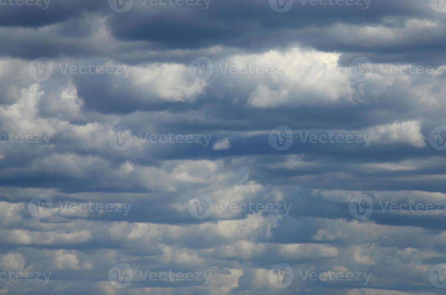 A blue sky with lots of white clouds of different sizes photo