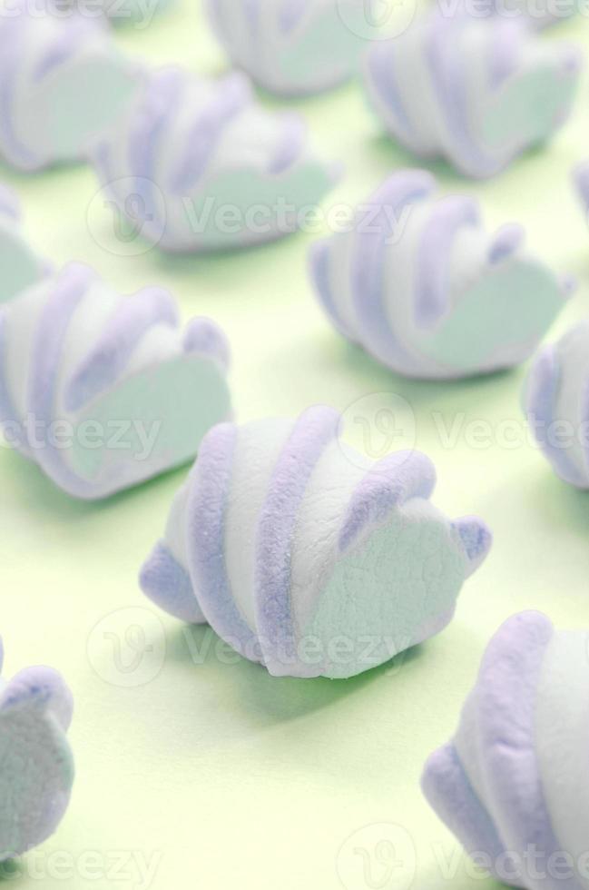 Colorful marshmallow laid out on lime paper background. pastel creative textured pattern photo