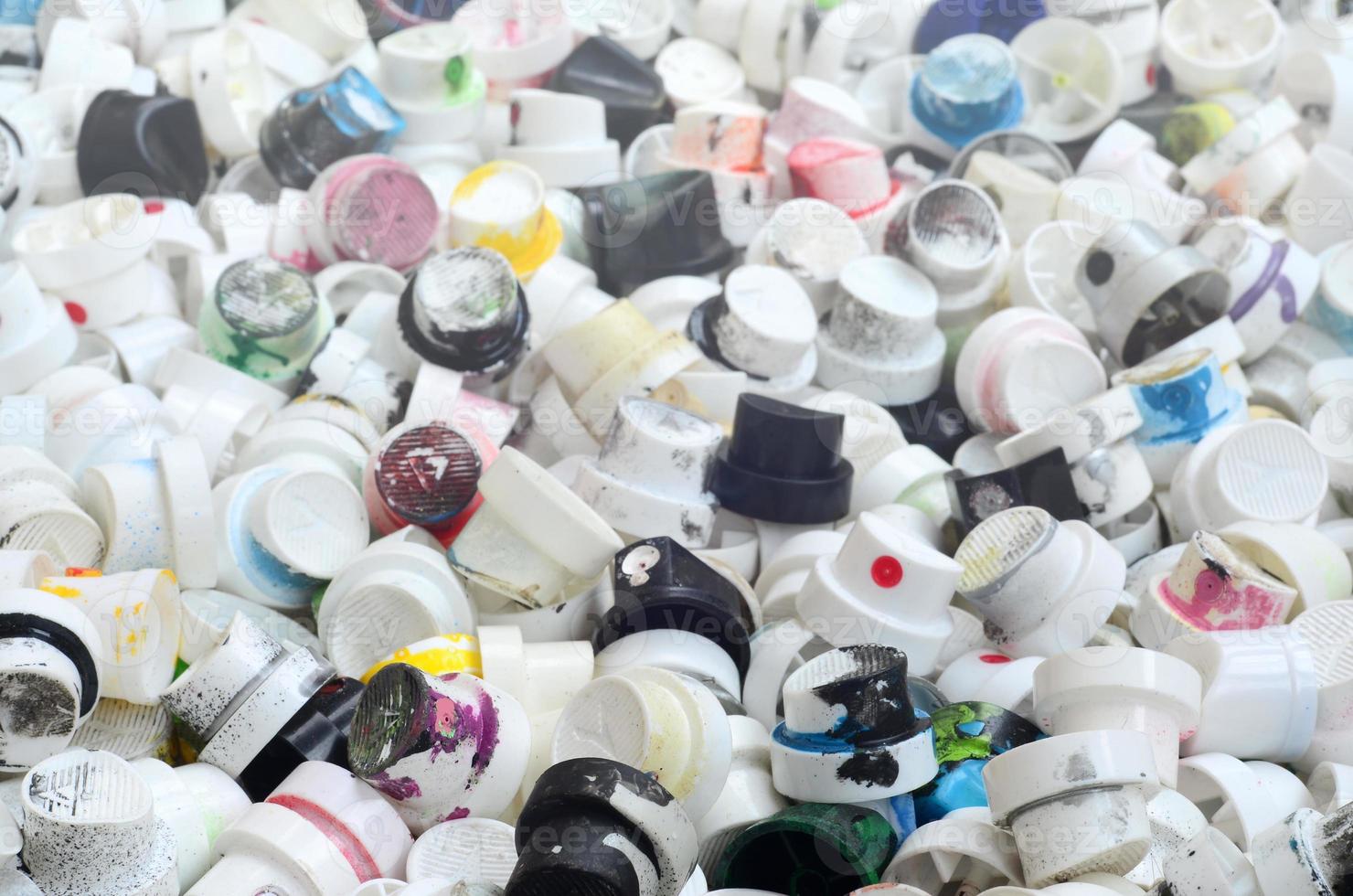 A pattern of many used and soiled nozzles from spray cans with aerosol paint. Background texture of the street art of drawing graffiti on the walls photo