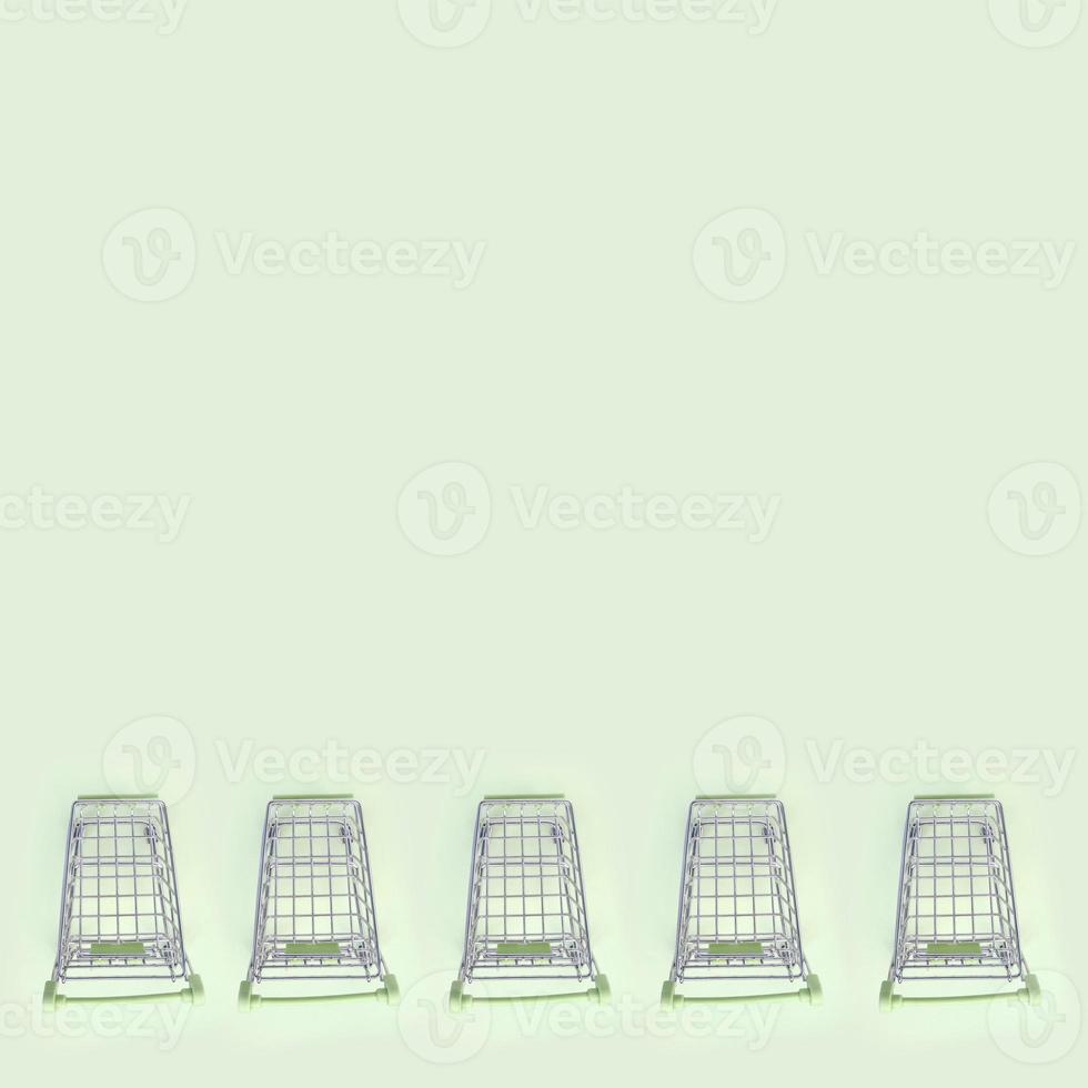 Pattern of many small shopping carts on a lime background photo