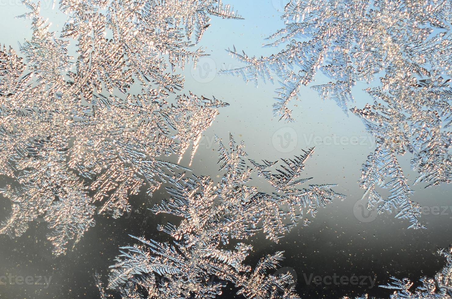 Snowflakes frost rime macro on window glass pane photo