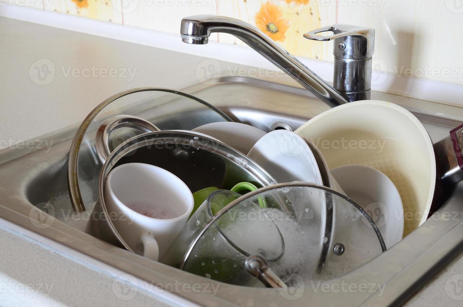 Dirty dishes and unwashed kitchen appliances filled the kitchen sink photo