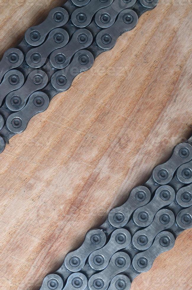 Dirty and oily chain from a mountain bike lying on a wooden table in a bicycle shop photo