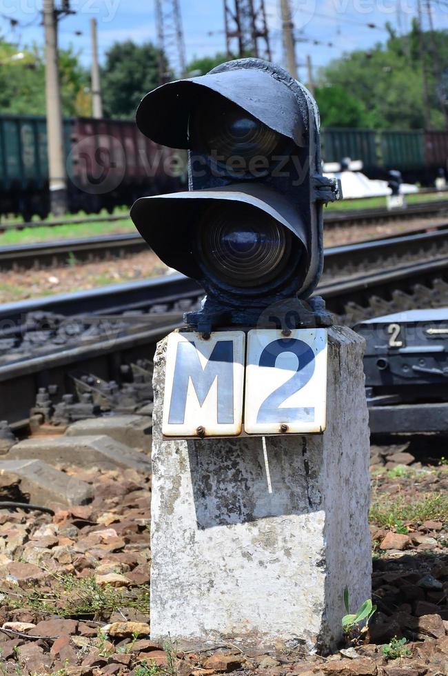 Railway traffic light semaphore against the background of a day railway landscape. Signal device on the railway track photo