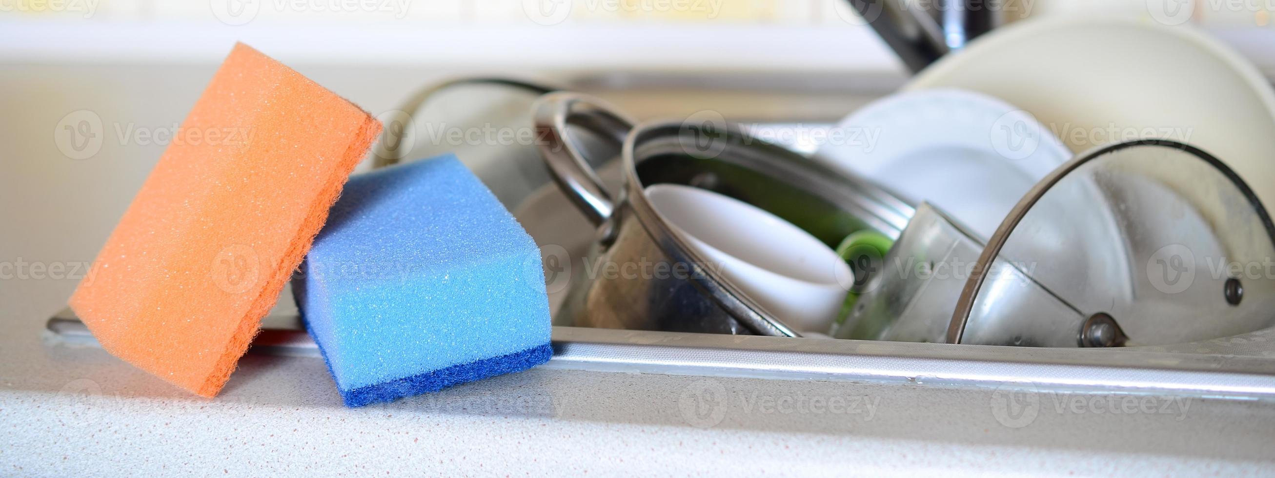 A few sponges lie on the background of the sink with dirty dishes photo