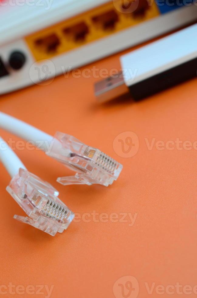 Internet router, portable USB wi-fi adapter and internet cable plugs lie on a bright orange background. Items required for internet connection photo