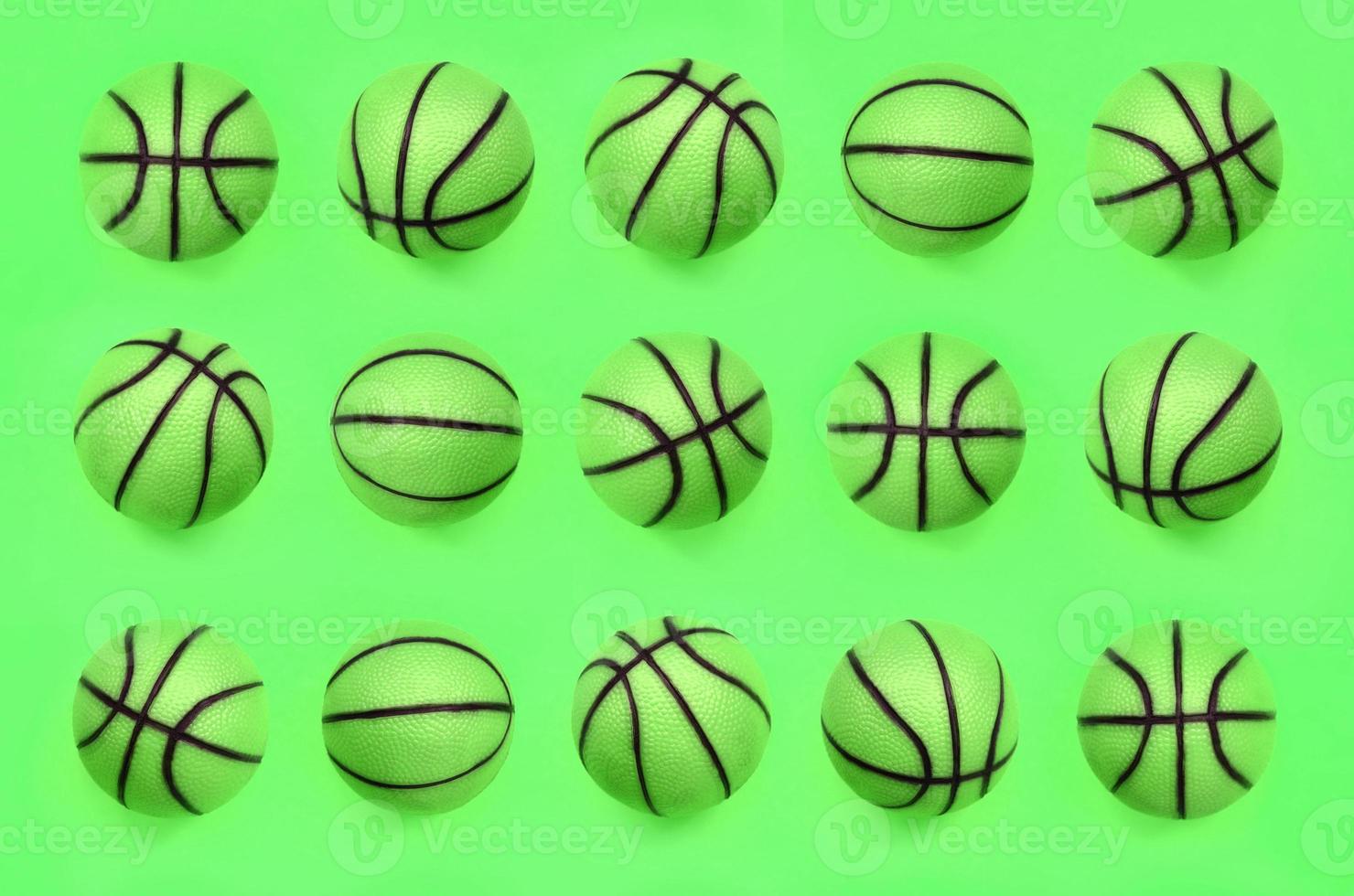 Many small green balls for basketball sport game lies on texture background photo