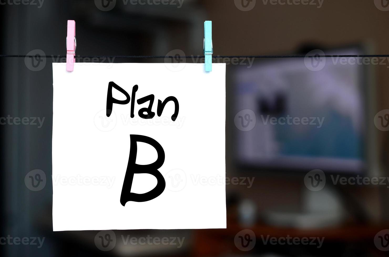Plan B. la nota está escrita en una pegatina blanca que cuelga con una pinza de ropa en una cuerda sobre un fondo del interior de la oficina foto
