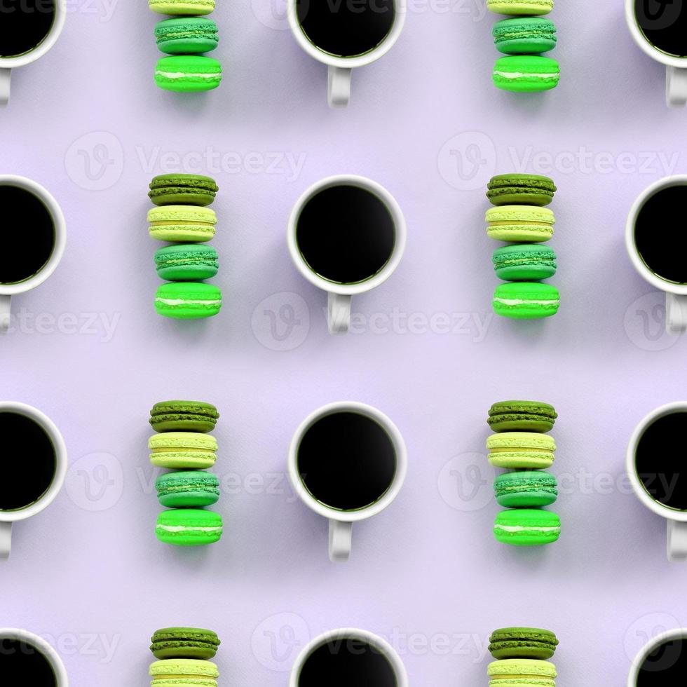 A pattern of many colorful dessert cake macaroon and coffee cups on trendy pastel lilac background top view photo