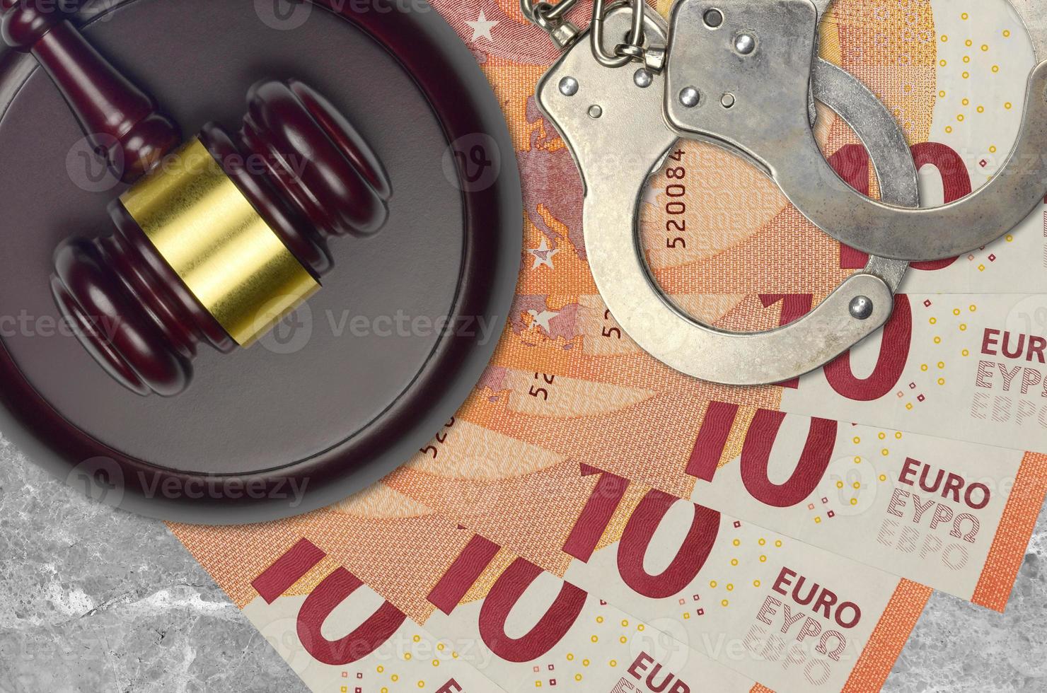 10 euro bills and judge hammer with police handcuffs on court desk. Concept of judicial trial or bribery. Tax avoidance photo