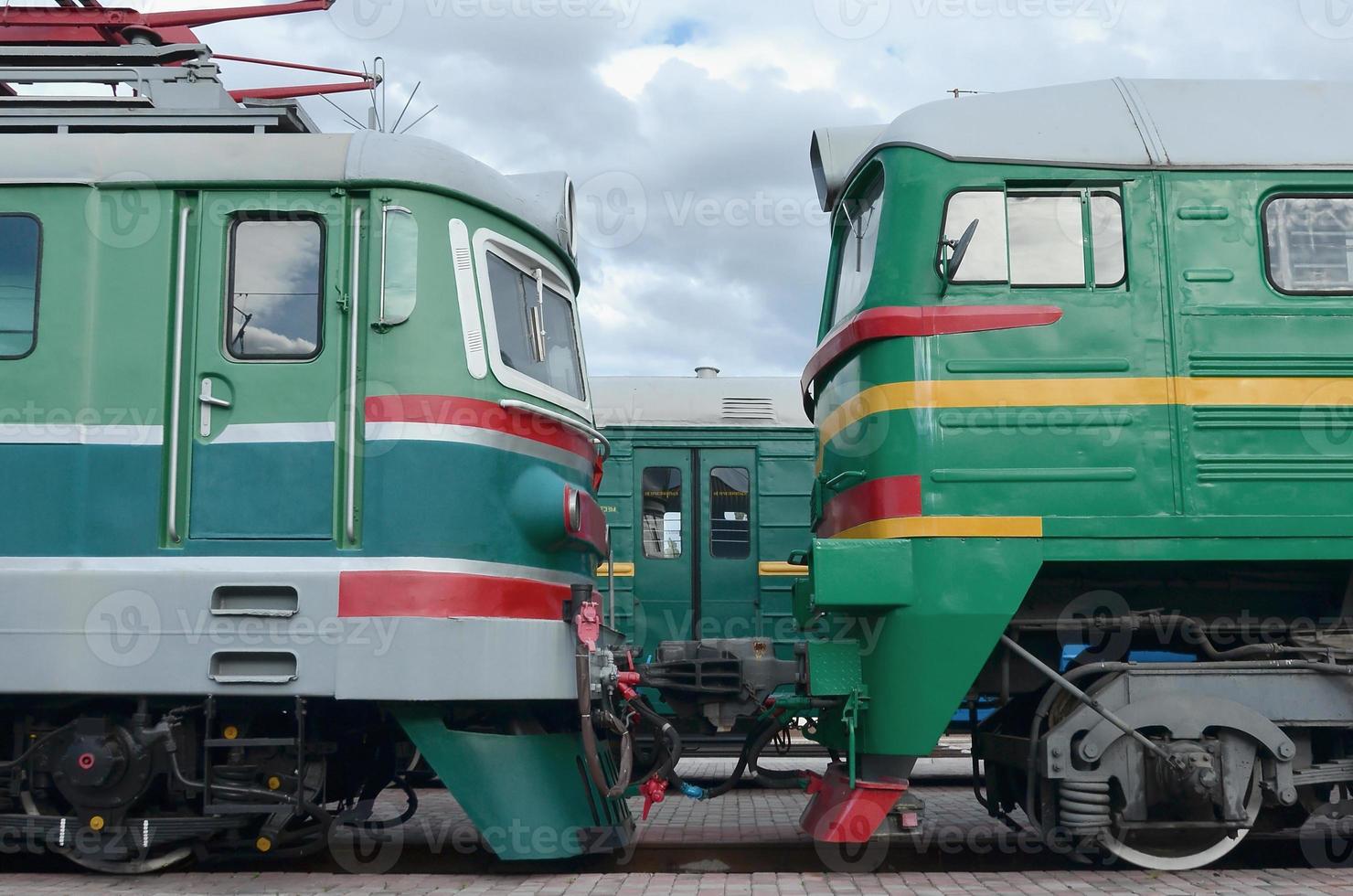 Cabs of modern Russian electric trains. Side view of the heads of railway trains with a lot of wheels and windows in the form of portholes photo