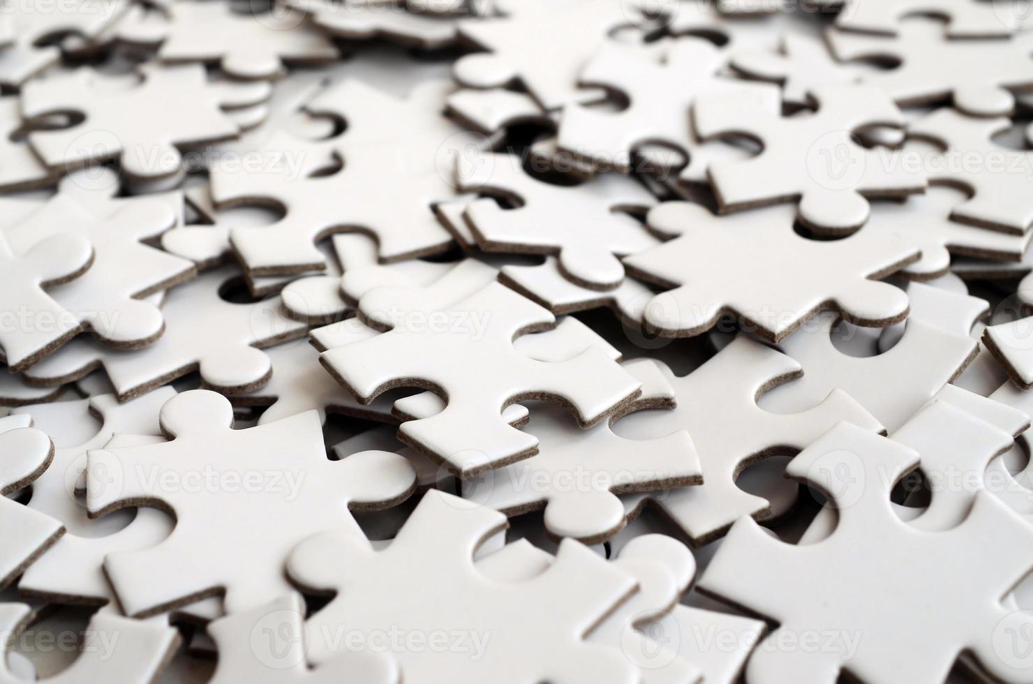 Close-up of a pile of uncompleted elements of a white puzzle. A huge number of rectangular pieces from one large white mosaic photo