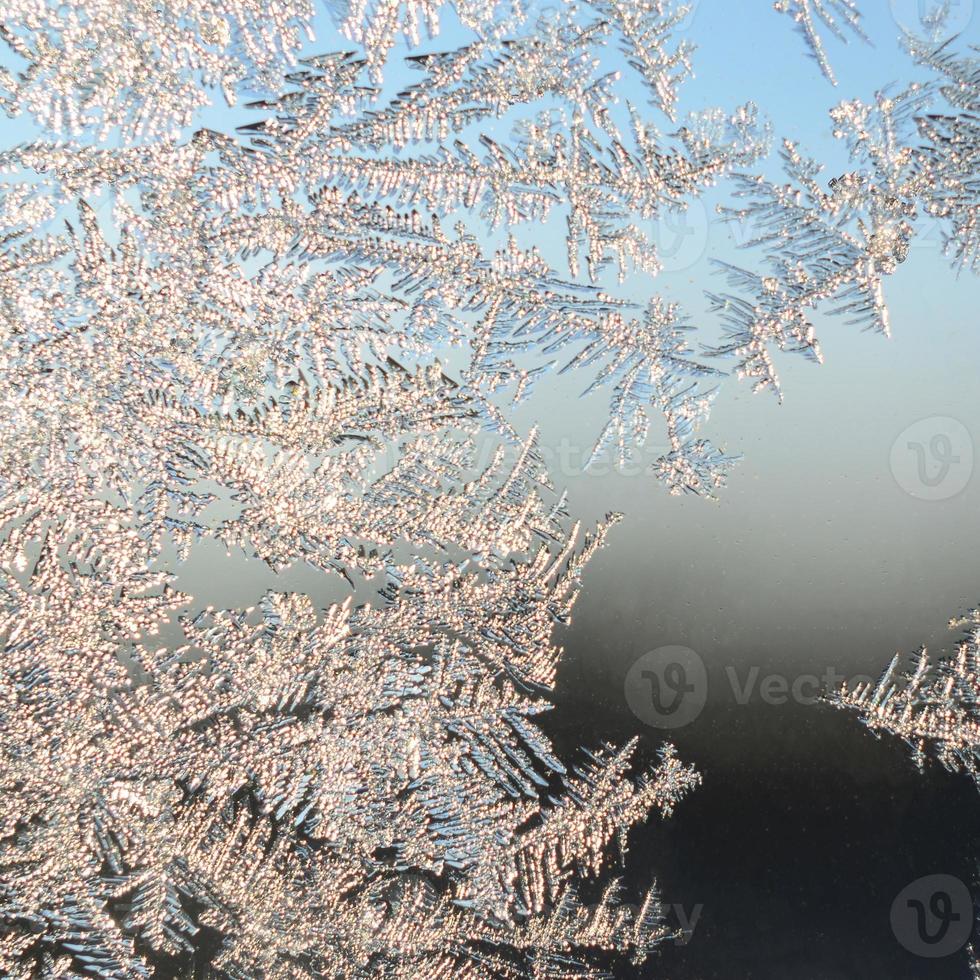 Snowflakes frost rime macro on window glass pane photo