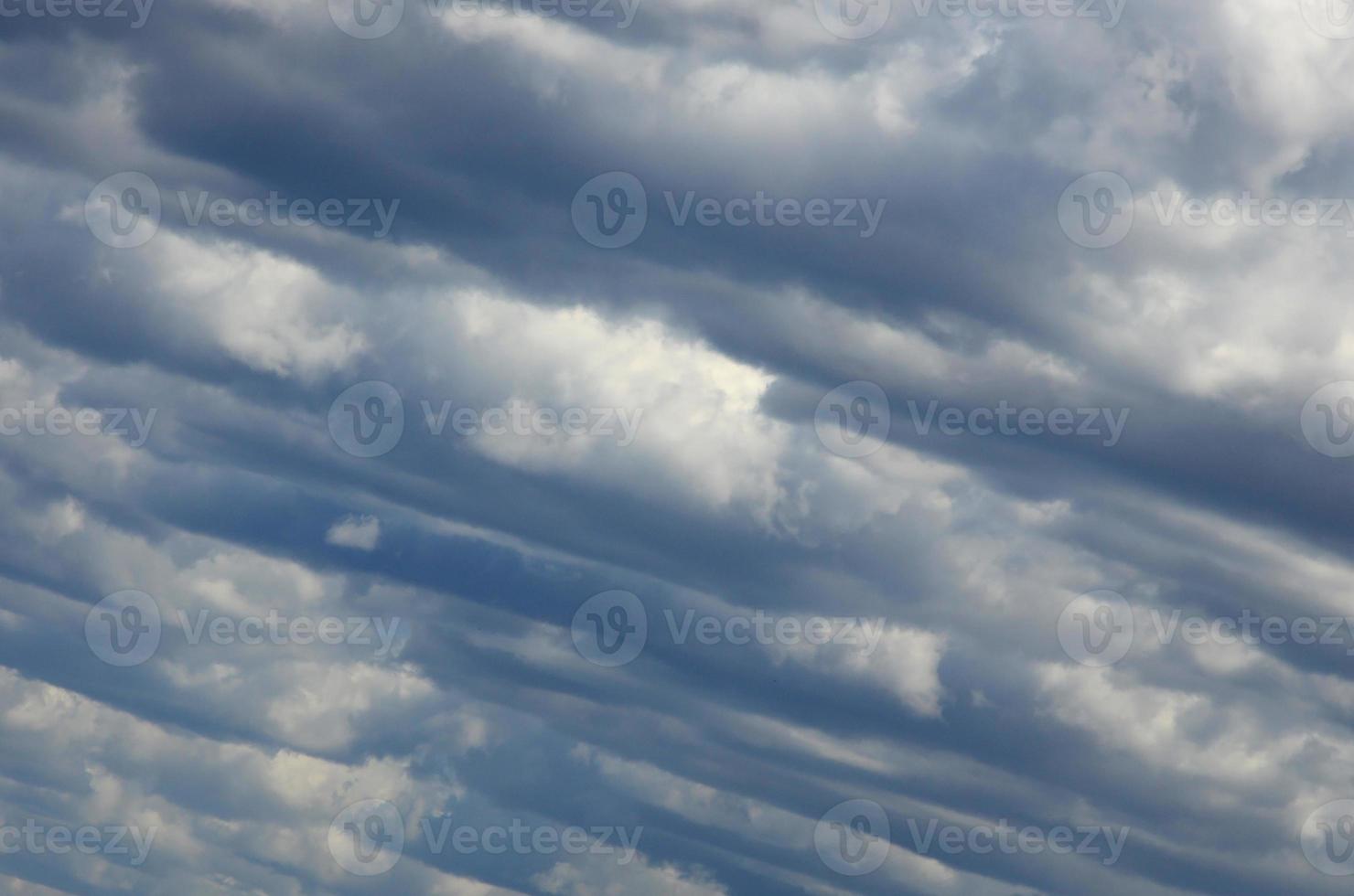 A blue sky with lots of white clouds of different sizes photo