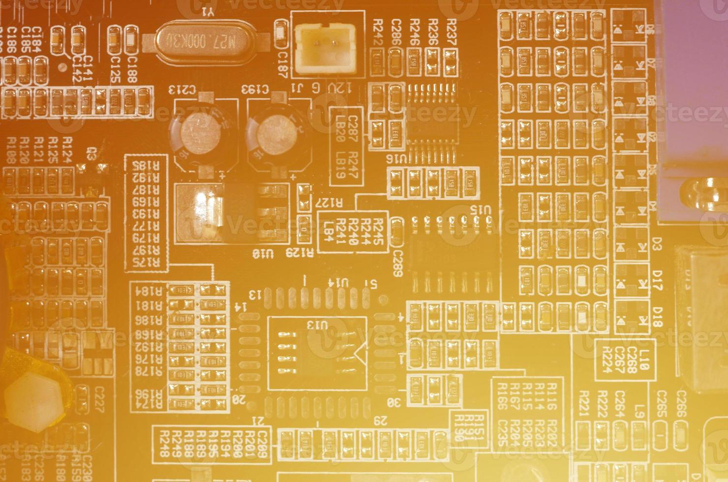 A toned macro image of a computer board with many small technological elements. Extremely shallow depth of field. Abstract technological background photo