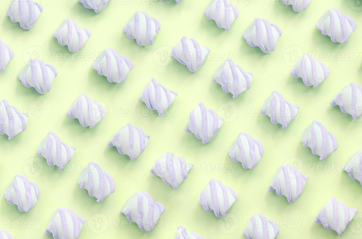 Colorful marshmallow laid out on lime paper background. pastel creative textured pattern photo