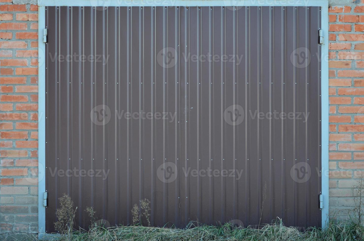 la textura de una puerta de metal pintada de un garaje de ladrillo foto