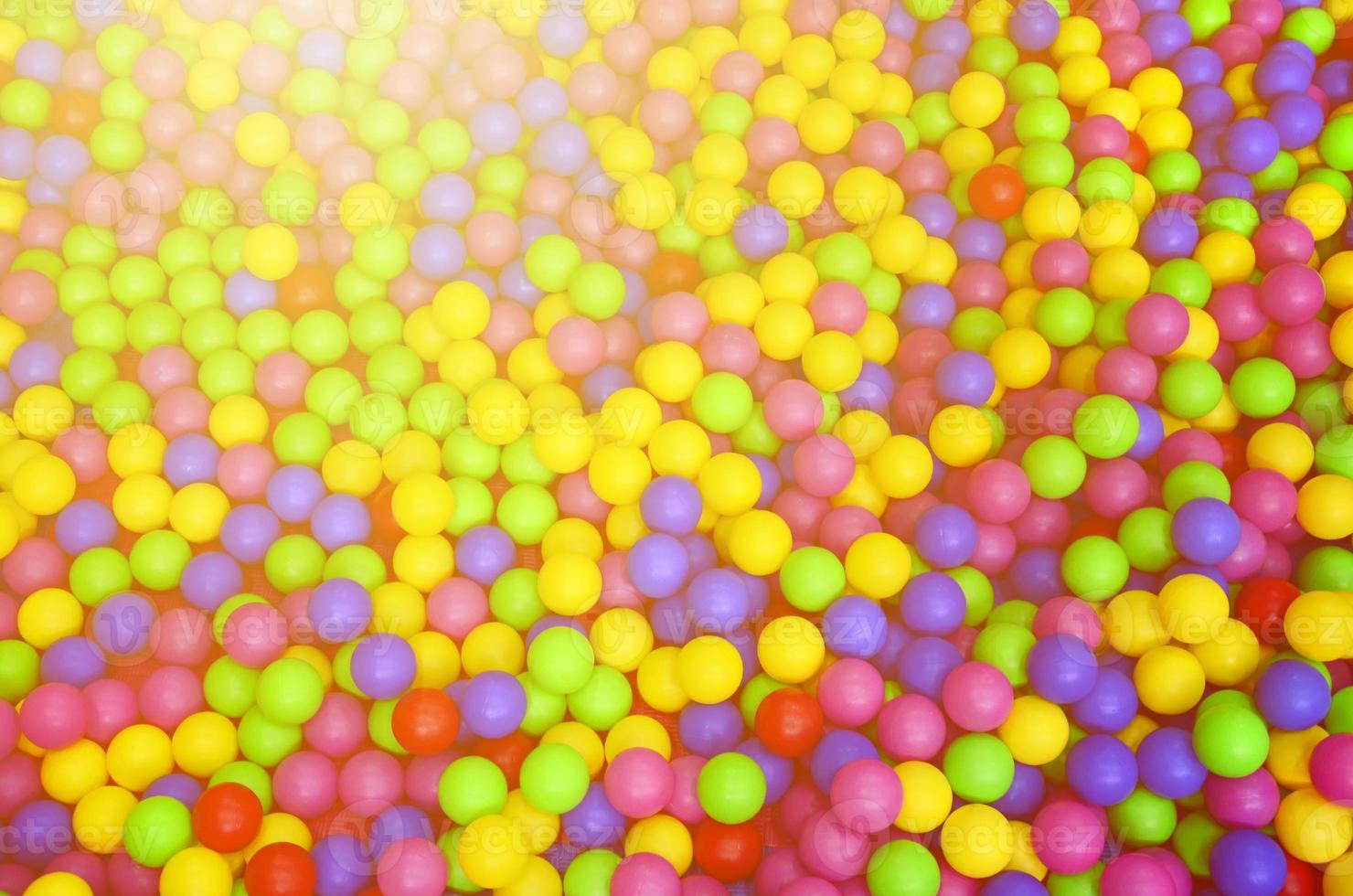 Many colorful plastic balls in a kids' ballpit at a playground. Close up pattern photo