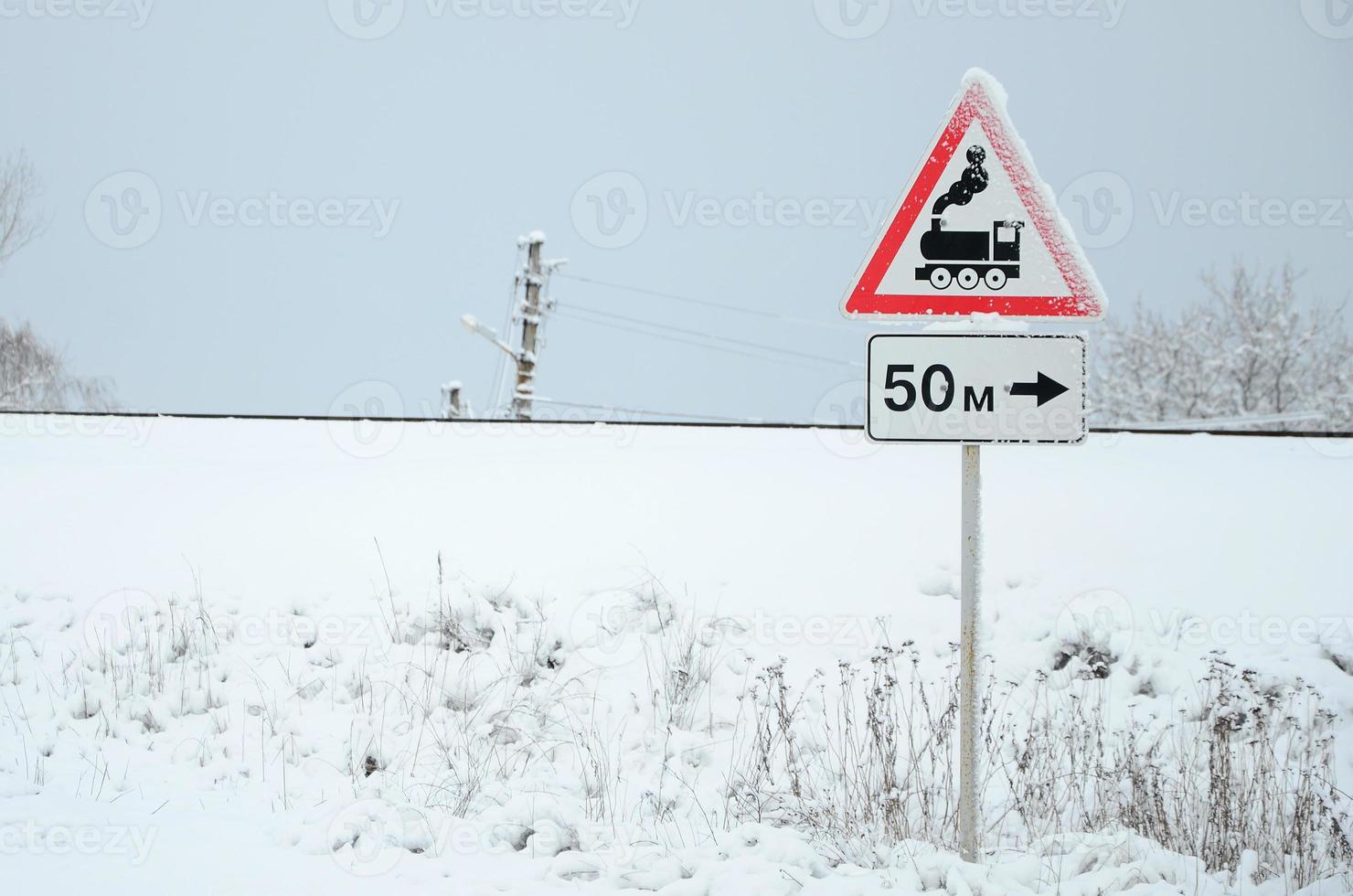 Railway crossing without barrier. A road sign depicting an old black locomotive, located in a red triangle photo