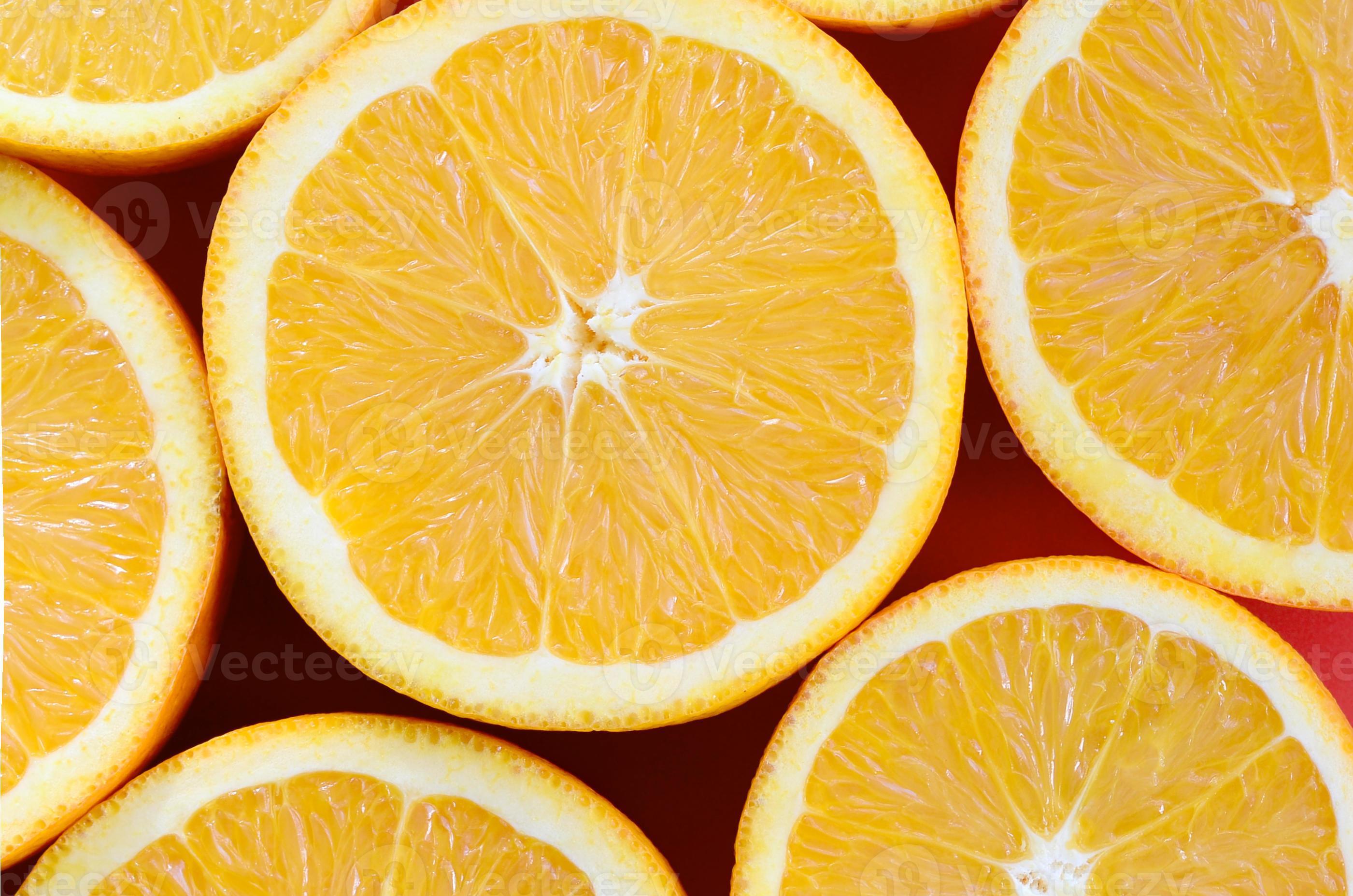 Top view of a several orange fruit slices on bright background in red