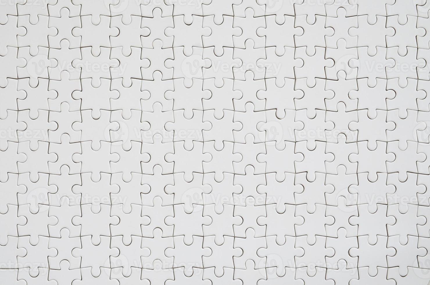 Close up texture of a white jigsaw puzzle in assembled condition. Top view. Many components of a large whole mosaic are united photo