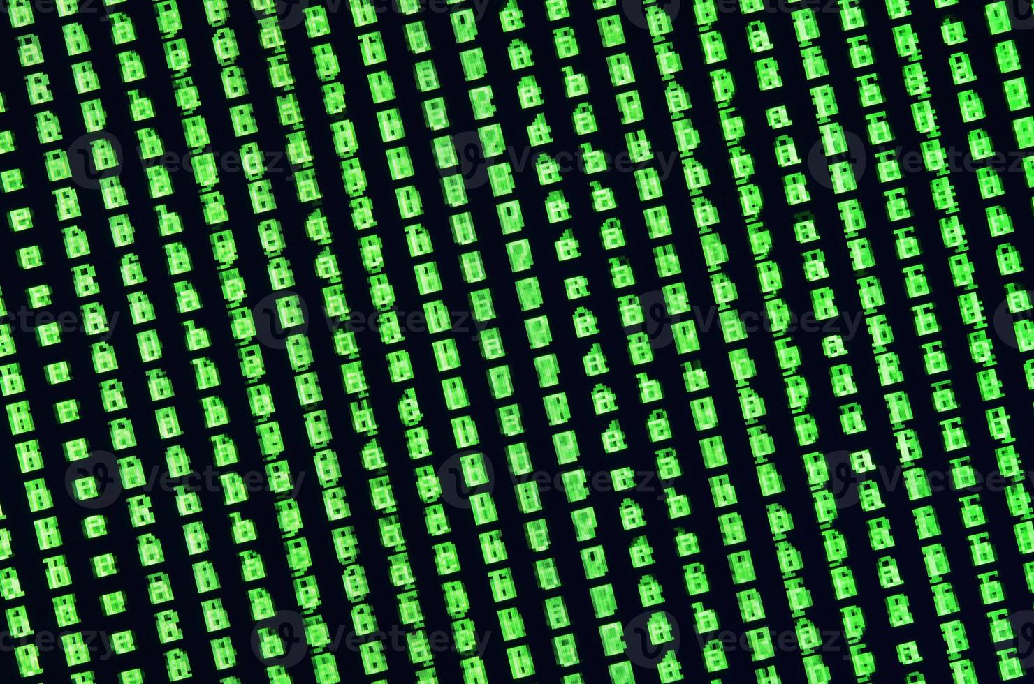 Macro shot of a glitch on the monitor of an office computer. The concept of introducing a virus into a personal data keeper. Stream of random green symbols on a black background photo