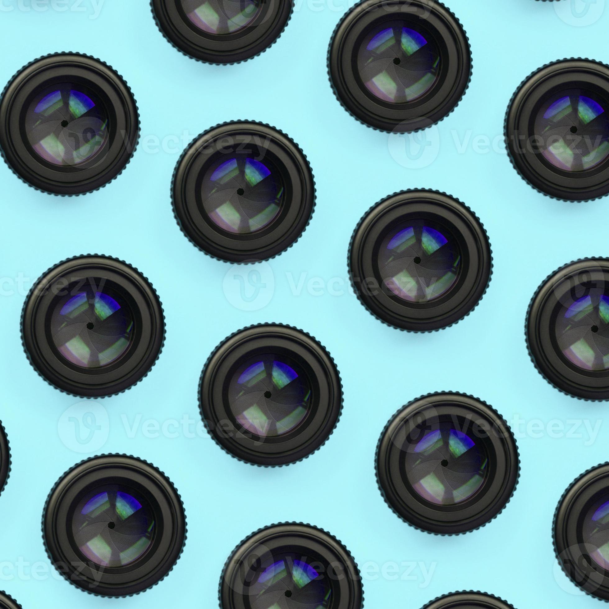 A few camera lenses with a closed aperture lie on texture background of