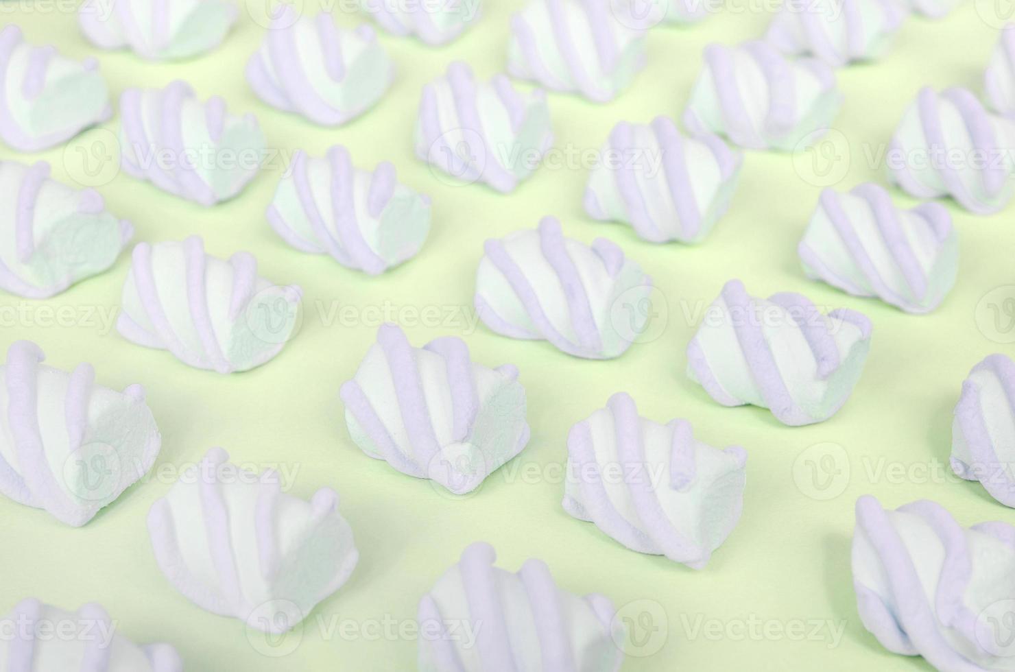 Colorful marshmallow laid out on lime paper background. pastel creative textured pattern photo