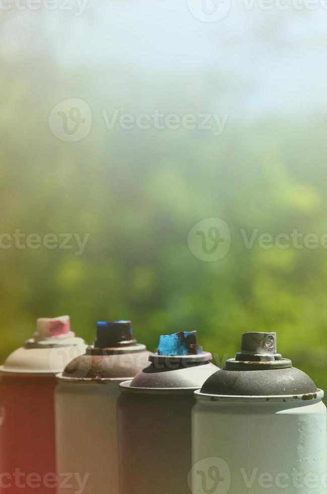 A few used aerosol paint sprayers lie on the windowsill in the workshop of a graffiti artist. The concept of street art and illegal drawing on the walls. Youth hobby photo