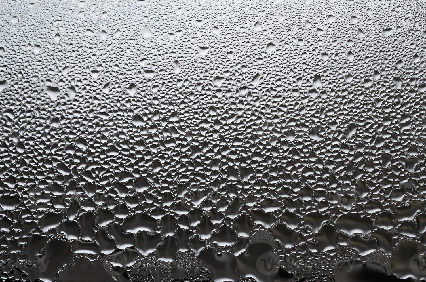 una foto de la superficie de vidrio de la ventana, cubierta con una multitud de gotas de varios tamaños. textura de fondo de una densa capa de condensado sobre vidrio