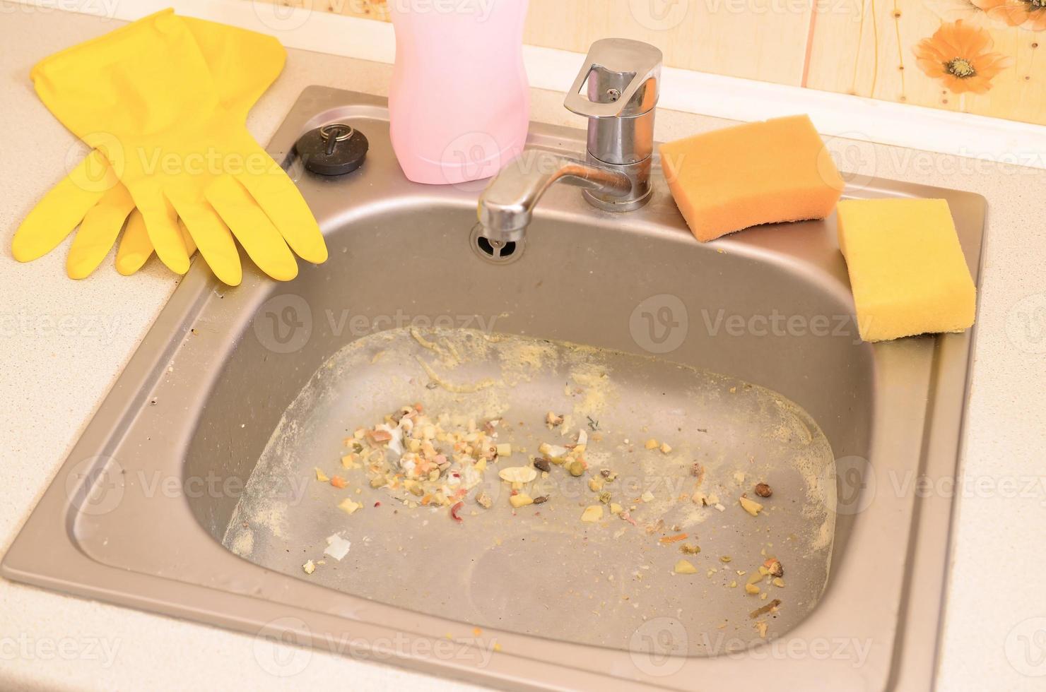 Close up on dirty clogging kitchen sink drain with food particles photo