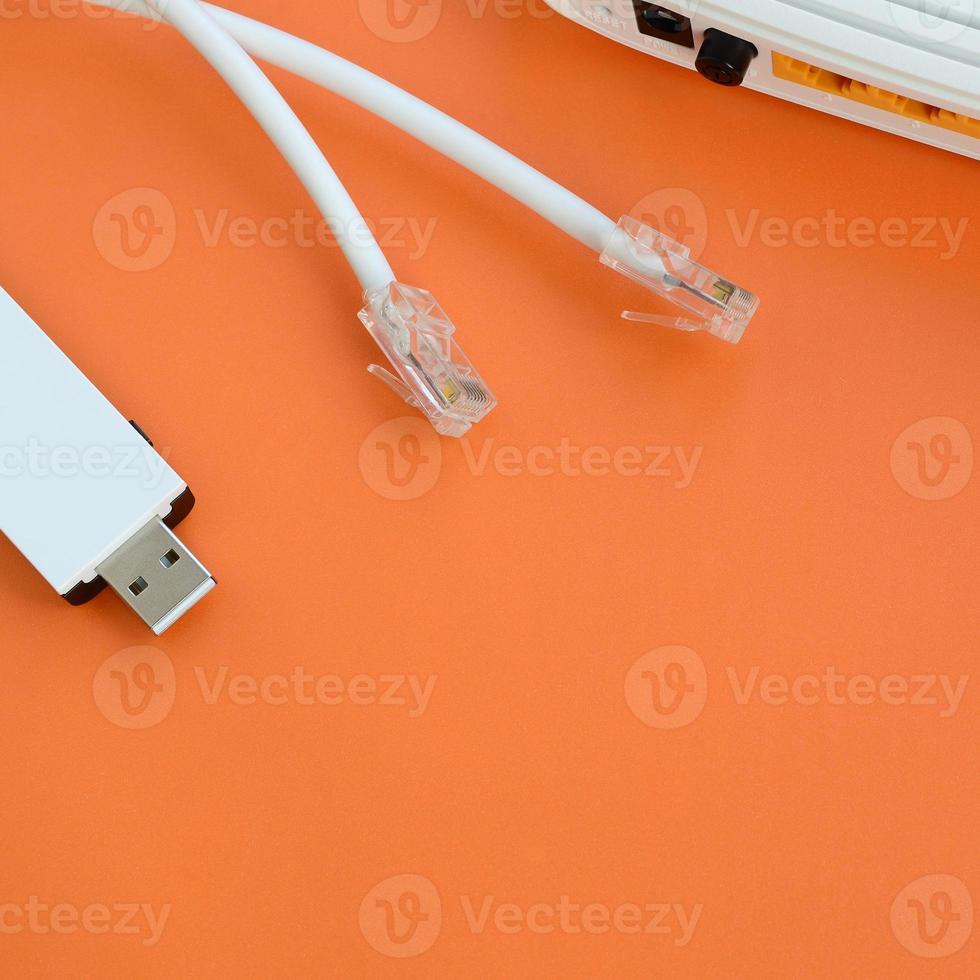 Internet router, portable USB wi-fi adapter and internet cable plugs lie on a bright orange background. Items required for internet connection photo