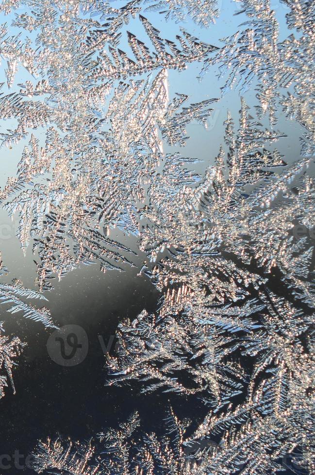 Snowflakes frost rime macro on window glass pane photo