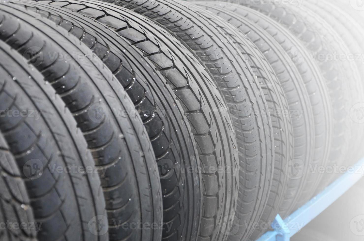 Rack with variety of car tires in automobile store. Many black tires. Tire stack background. Selective focus photo