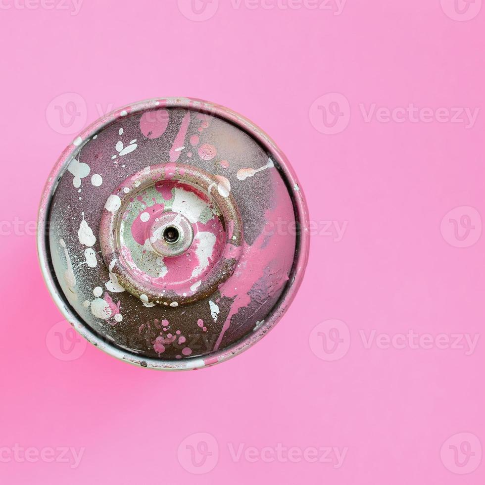 Used spray can with pink paint drips lie on texture background of fashion pastel pink color paper in minimal concept photo