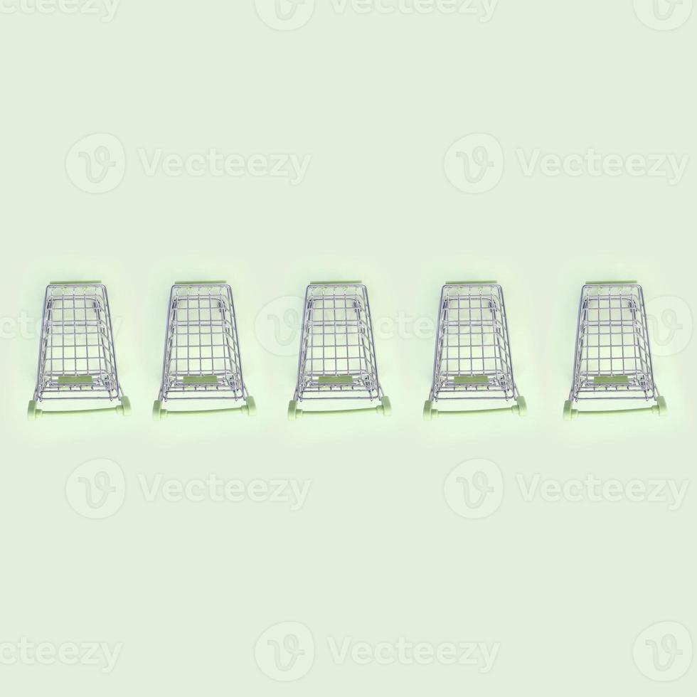 Pattern of many small shopping carts on a lime background photo