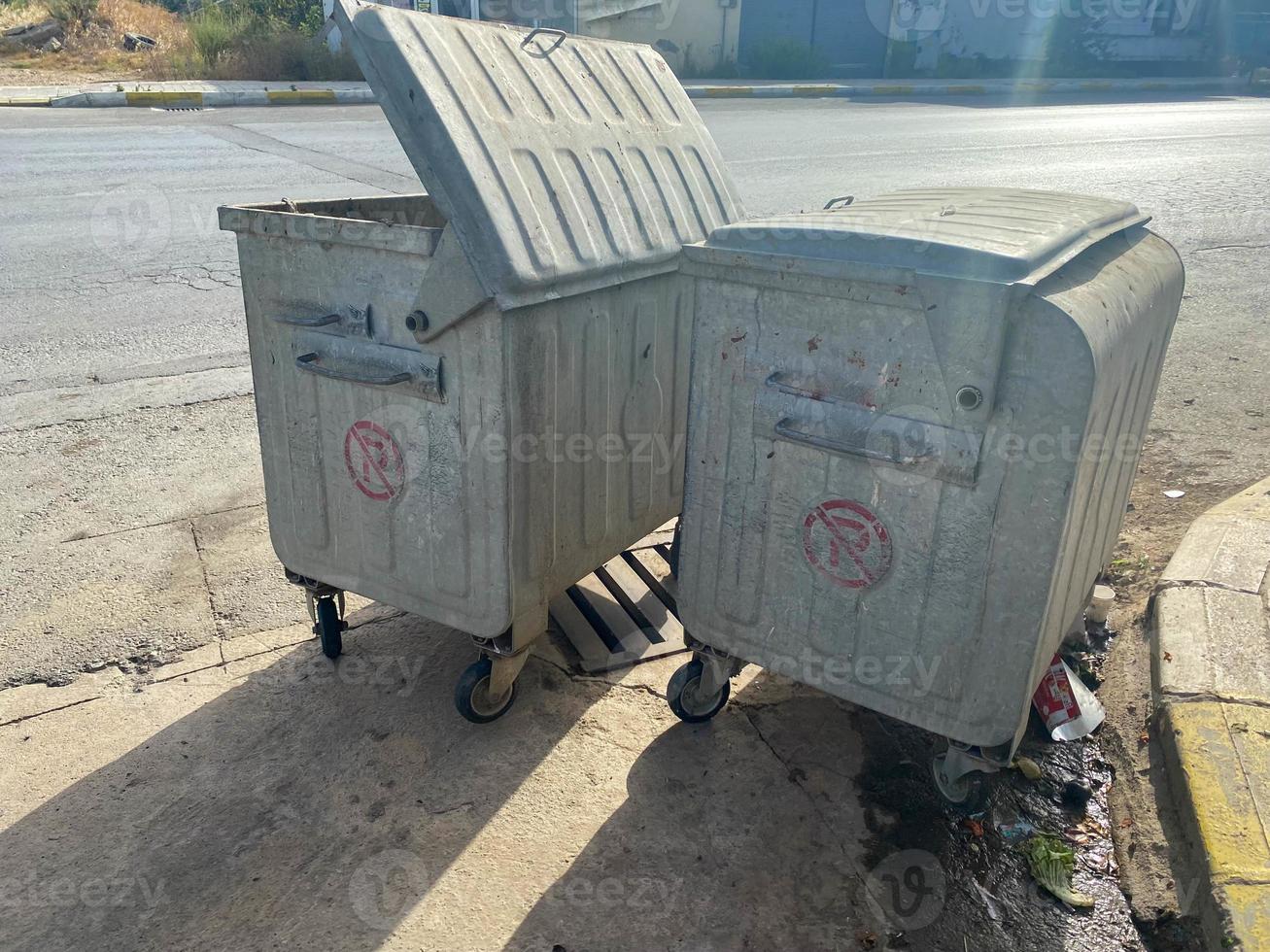 Large iron shiny metal containers for garbage and waste on wheels