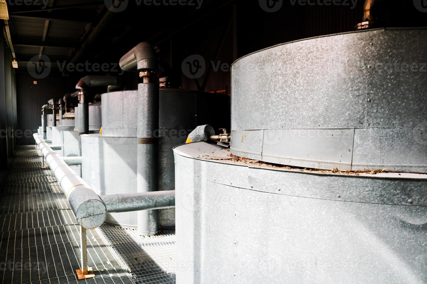 Large iron heat exchanger, tank, reactor, distillation column in thermal insulation of fiberglass and mineral wool of galvanized steel in the industrial refinery petrochemical plant shop photo