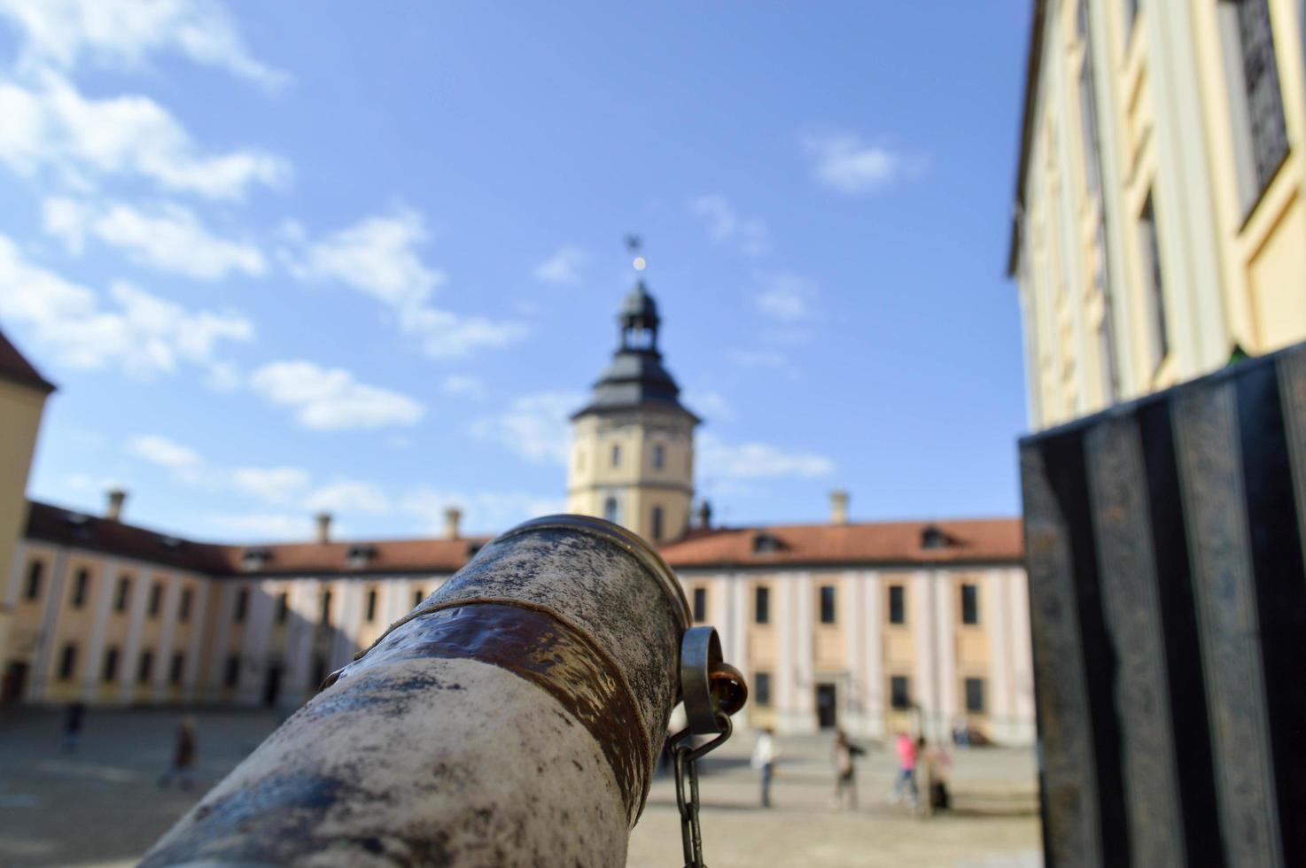 A look from an old ancient spyglass on a European medieval tourist building, a castle, a palace with a spire and a tower photo