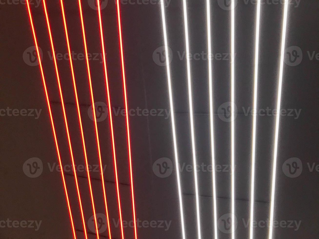 Blurred, no focused, abstract festive vertical background with red, orange and white neon led stripes on a black background, photography for creative workspace for design photo