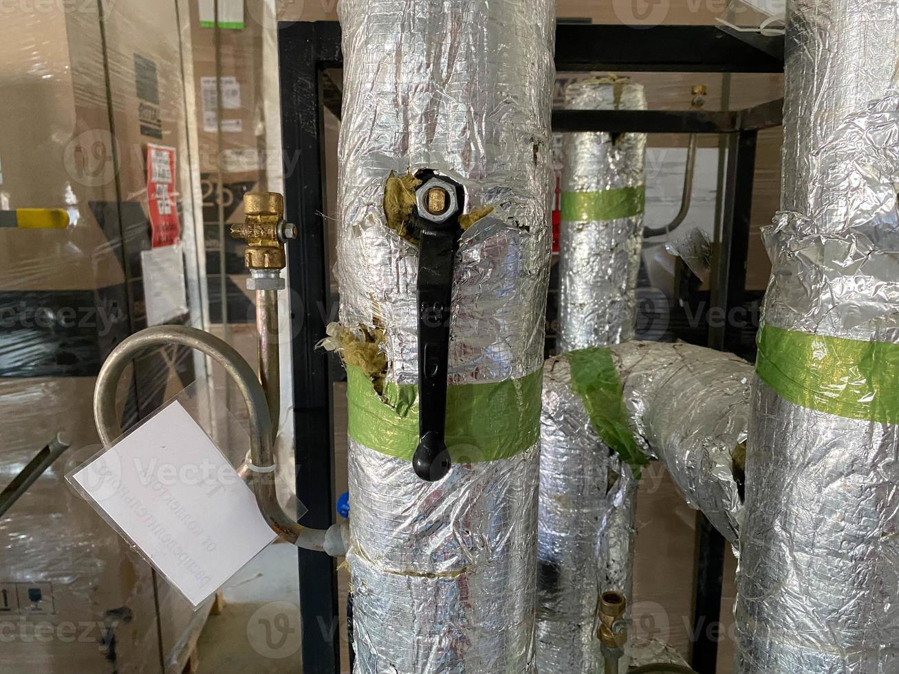 Pipes with tubes and flanges in silver mineral wool thermal insulation to save heat for pumping liquids in refinery petrochemical plant equipment photo