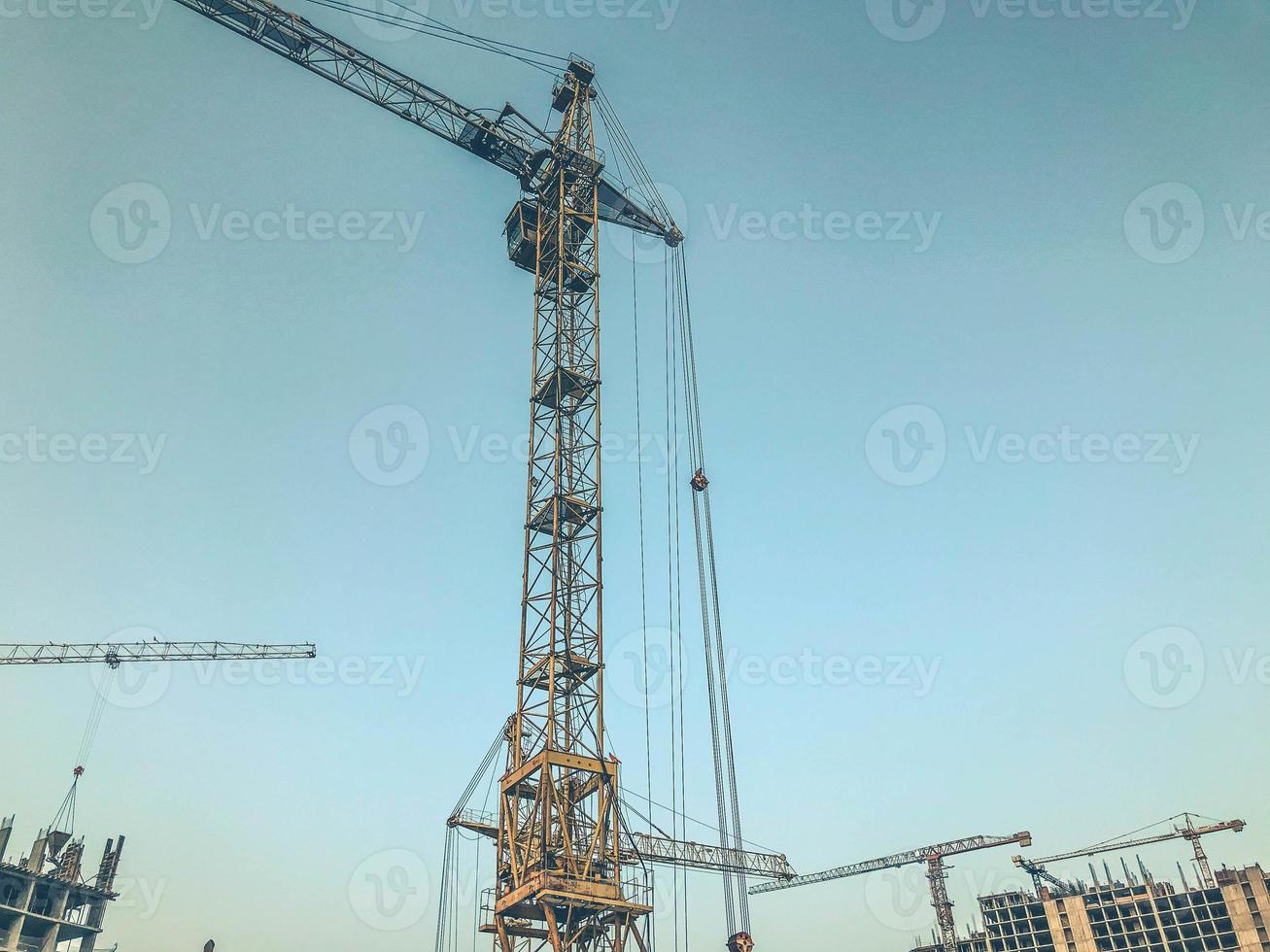 construction pit. construction site of the new district. metal lifting cranes. construction of concrete tall buildings in gray. large concrete boxes. urban landscape photo