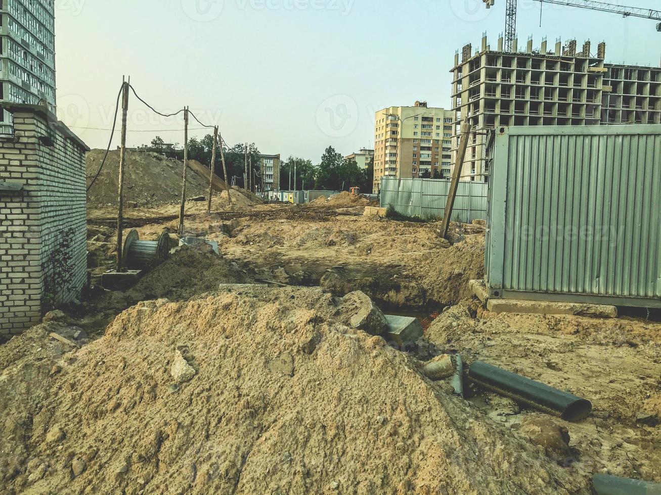 abandoned construction site. old, tall and gray concrete houses. the abandoned area is surrounded by a gray metal fence. the passage of people is prohibited. dangerous area photo
