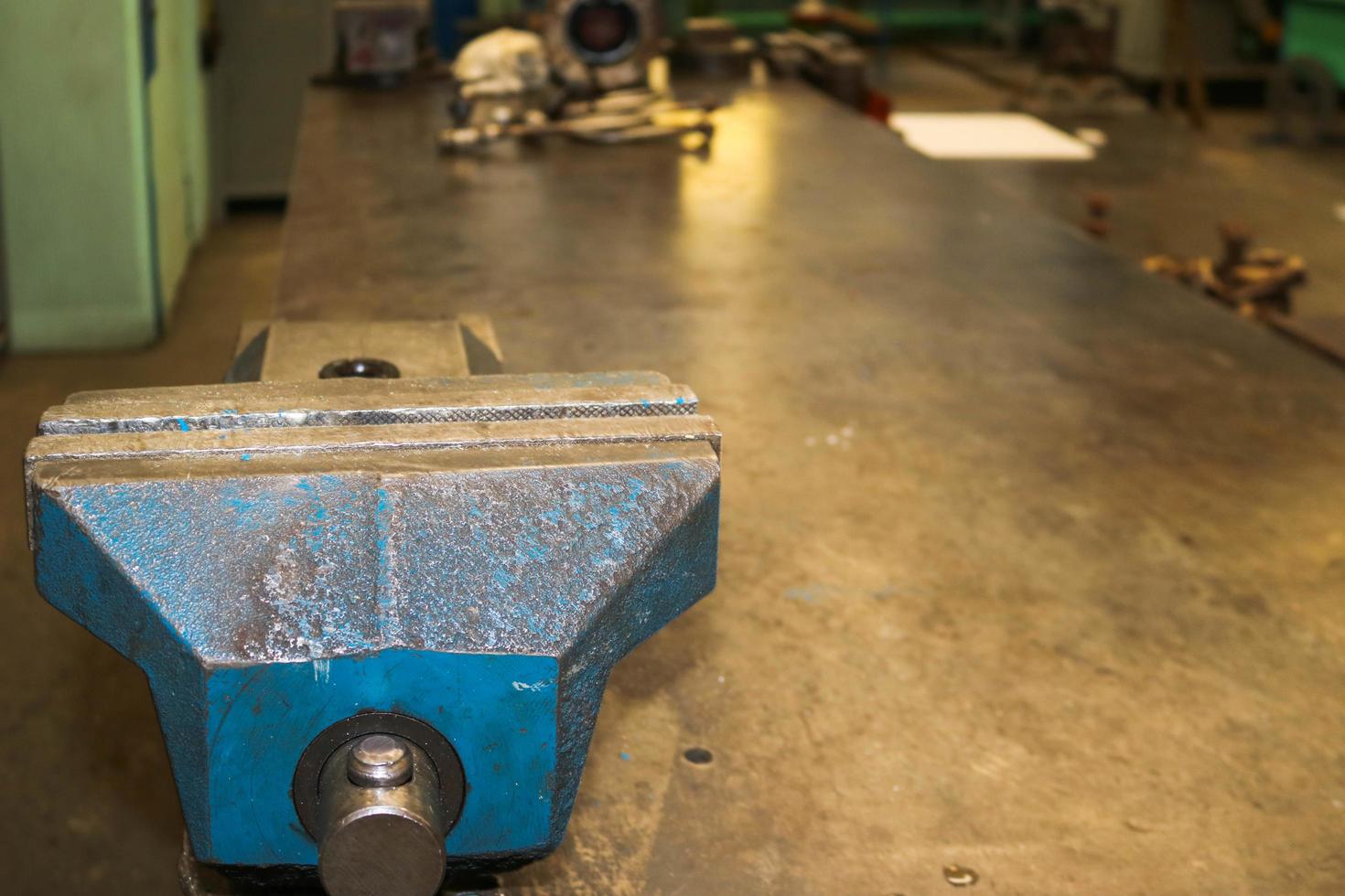 Metal iron industrial vise in a metal workshop on the table for the repair and manufacture of parts and spare parts photo