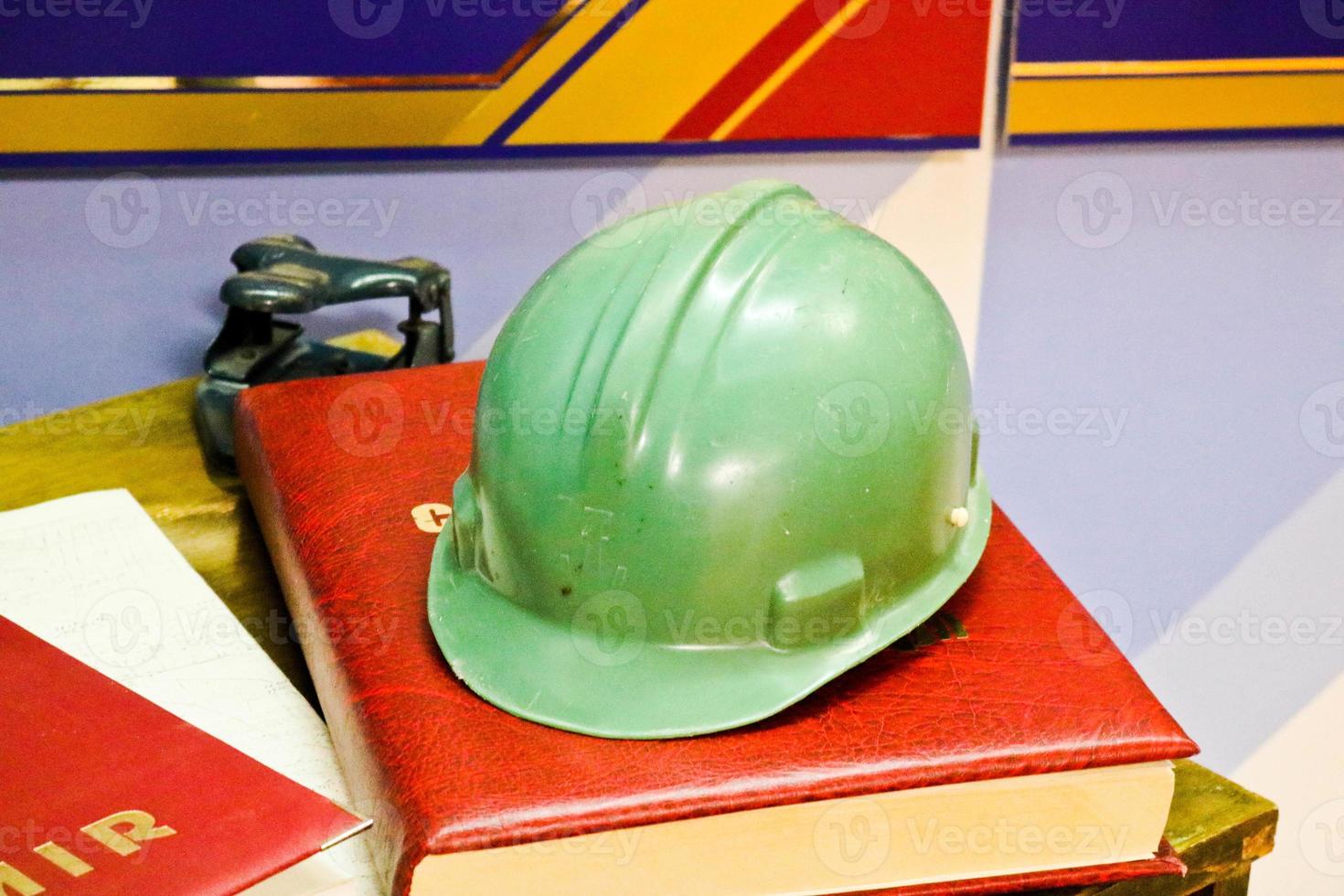 Green plastic safety helmet for the worker. Protective helmet to protect the head of people operating in hazardous conditions at the factory photo