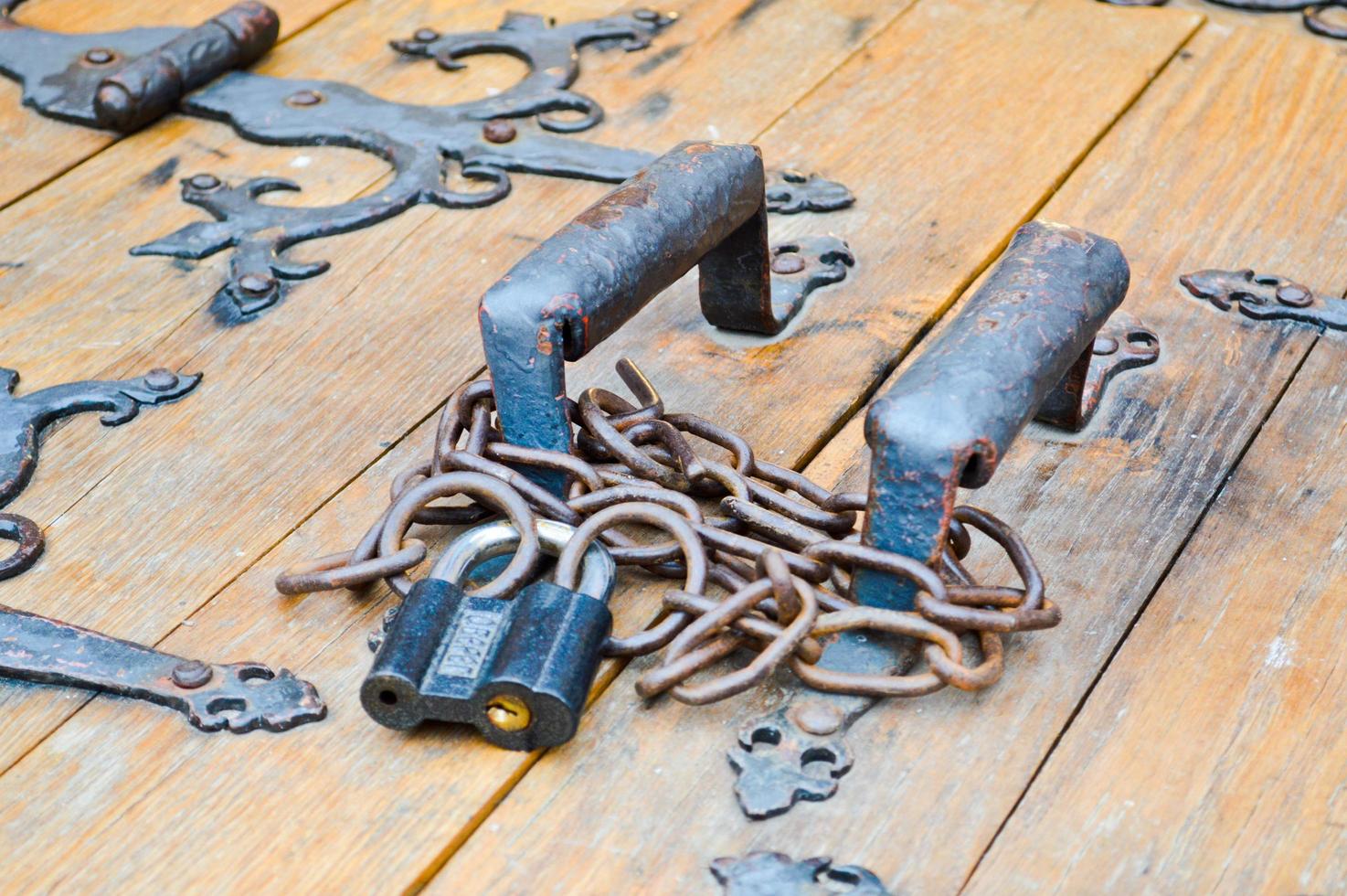Texture of old ancient medieval antique sturdy wooden natural thick door with rivets and nails patterns and locks made of wooden planks. The background photo