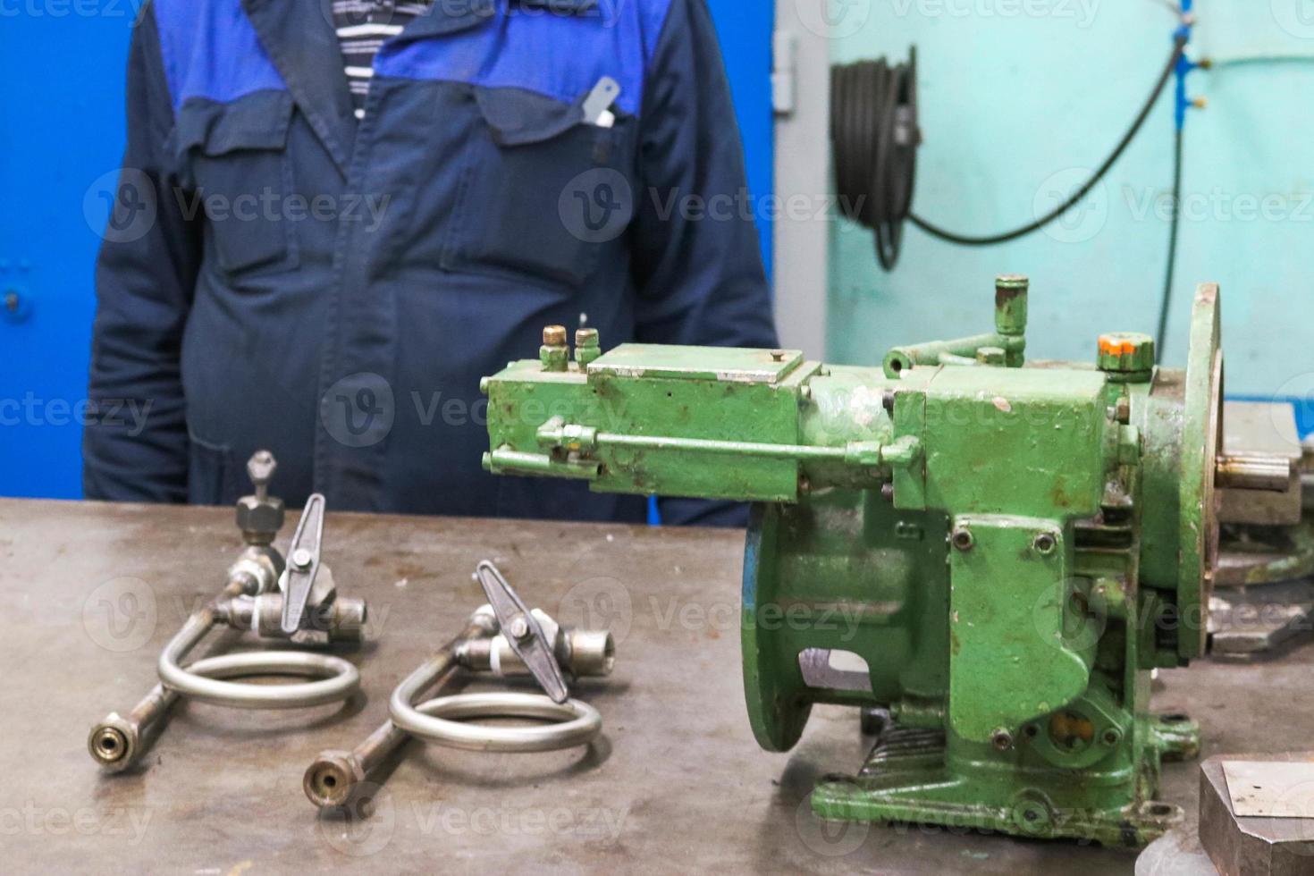 émbolo de bomba industrial de hierro metálico, montaje centrífugo y manométrico en un taller de metal sobre la mesa para la reparación y fabricación de piezas y repuestos foto